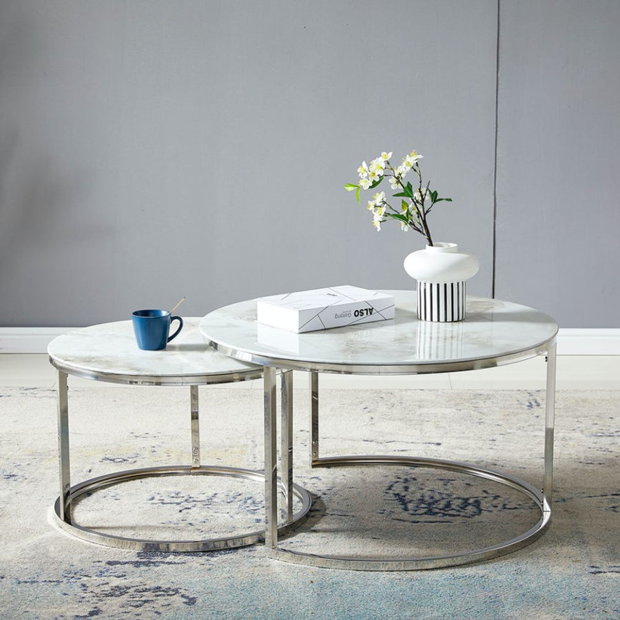 Deux tables basses rondes gigognes, plateaux effet marbre et pieds chromés